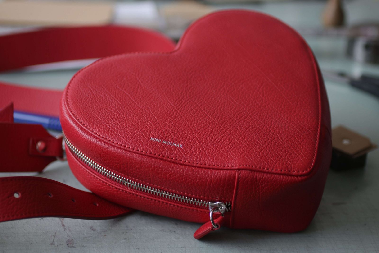 Red heart-shaped leather bag on the workbench